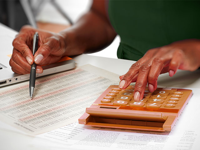 Woman working on accounting problem with calculator