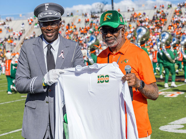 receives Marching 100 appreciation gift from Band Director Shelby Chipman, Ph.D. (Glenn Beil)