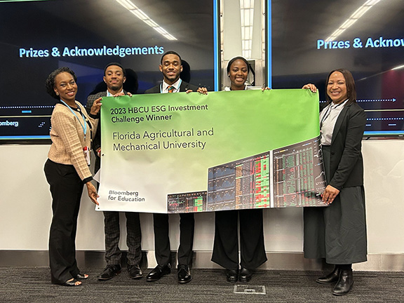 Professor Inger M. Daniels-Hollar, Ph.D., with Jalen Mason, Jaeden Patterson and Bloomberg representatives.