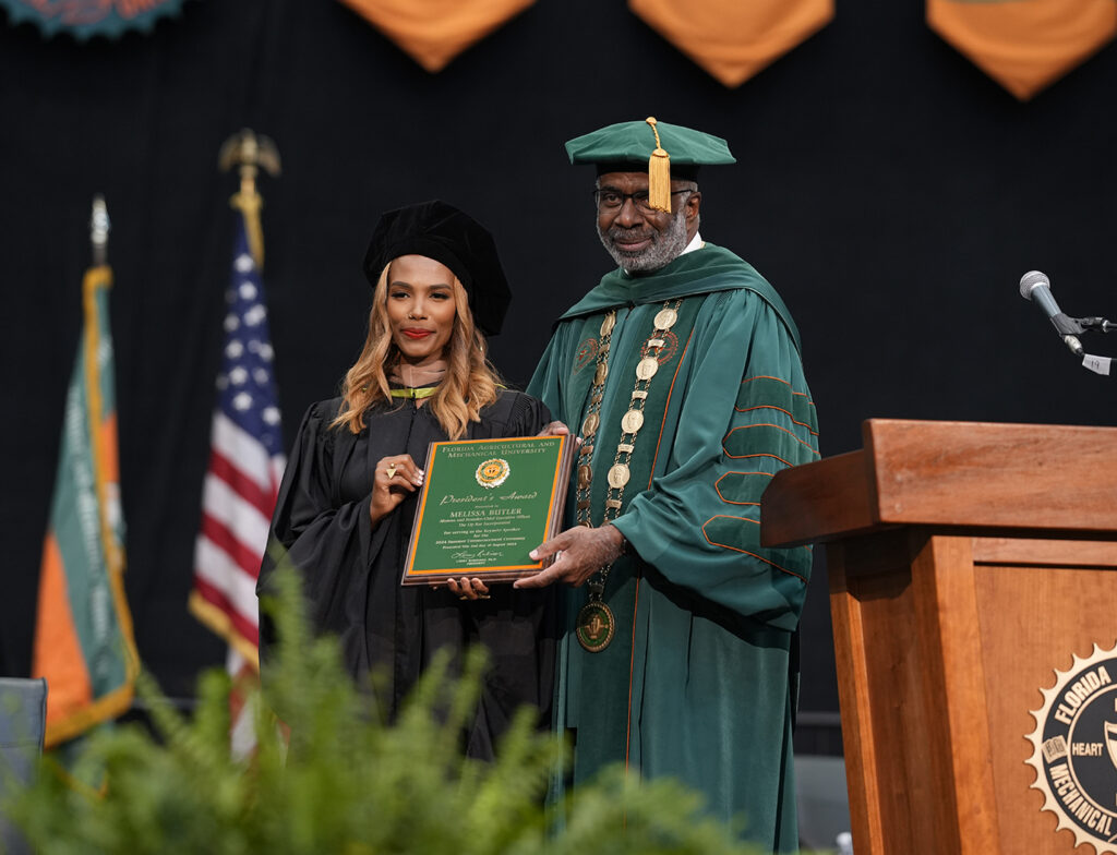 Melissa Butler receives the President’s Leadership Award from President Larry Robinson, during his final public event as president. (Credit: Ernest Nelfrard)