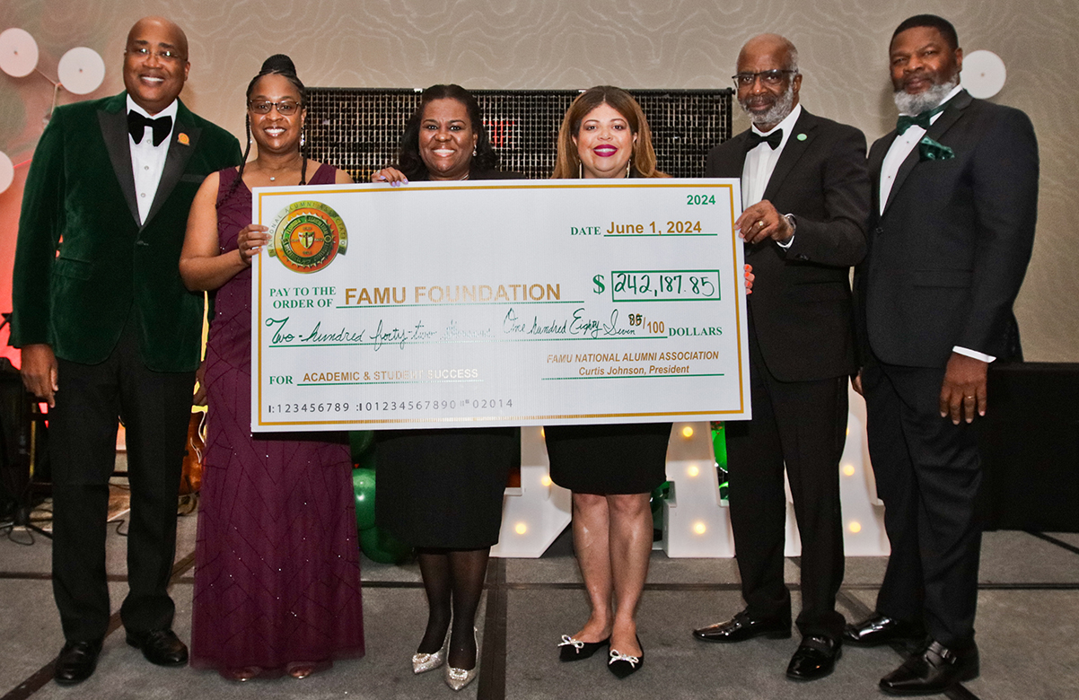 FAMU NAA President Curtis Johnson and others present a check of donations during a NAA Fundraising Breakfast at the Tampa convention. (Credit: Ricky Roberts)