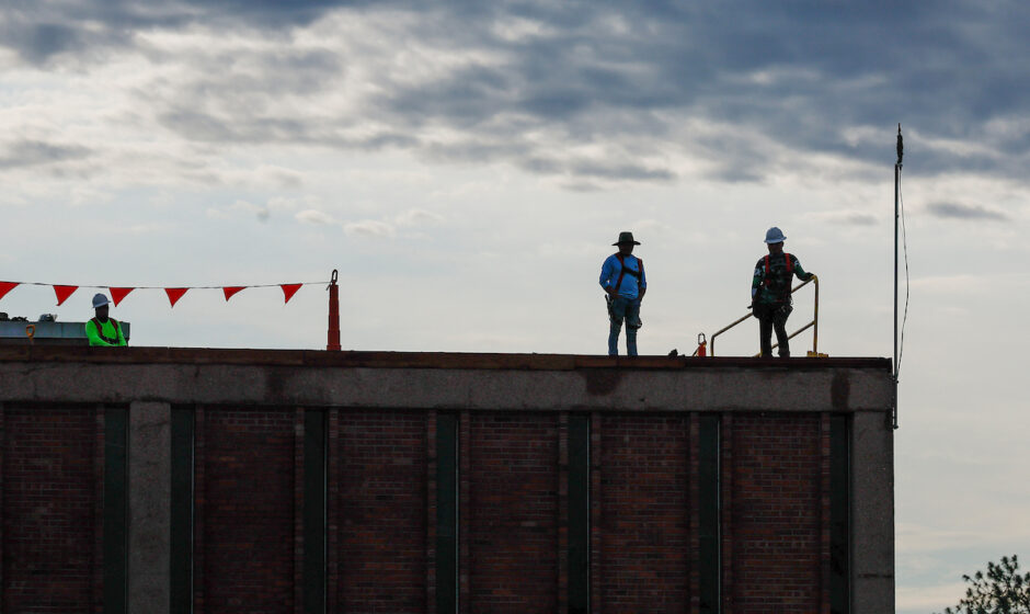 Workers on building inspecting storm damage