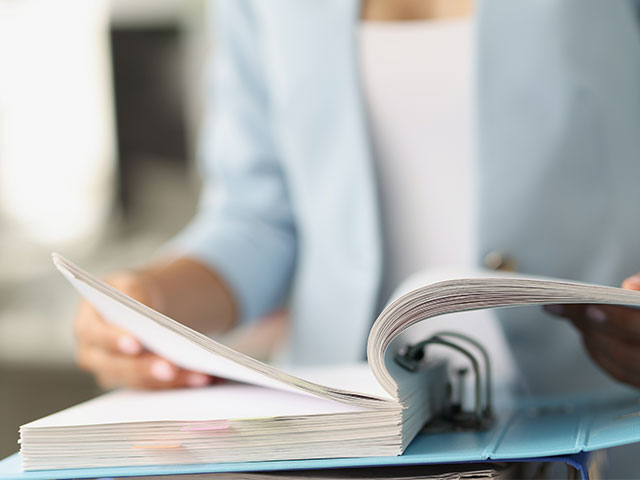 Woman going through binder of documents