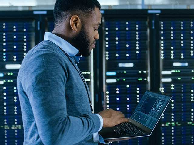 Man with laptop in computer server room