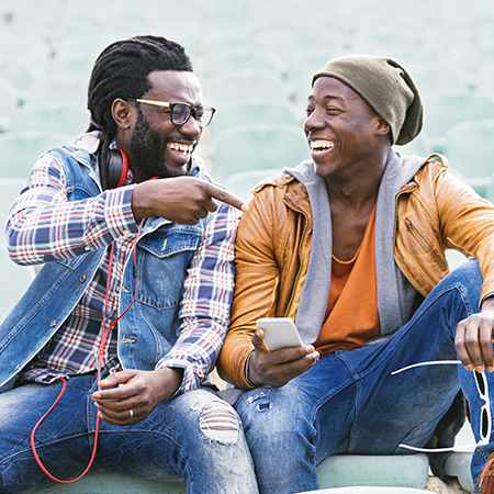 two young adult men smiling and pointing at eachother