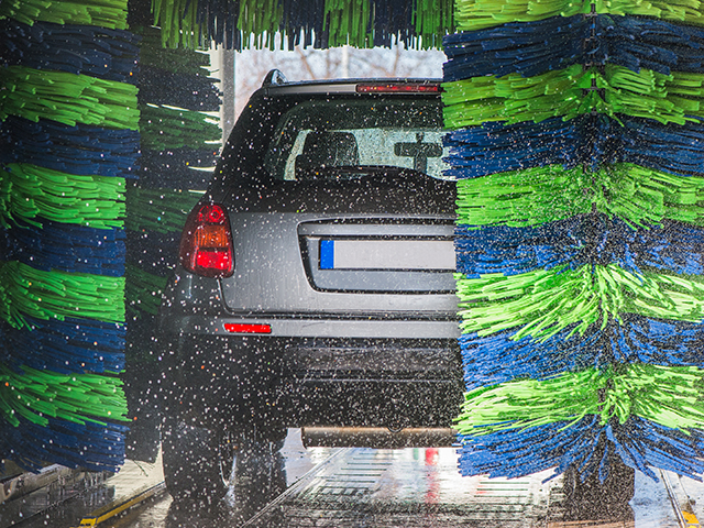 Grey car in a drive trough car wash