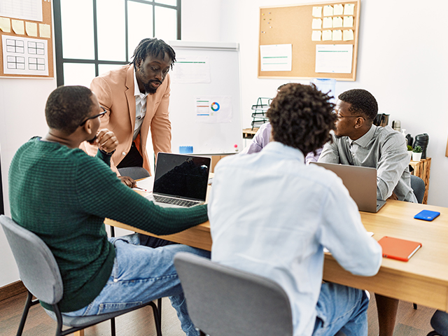 Team of employees sitting around a desk