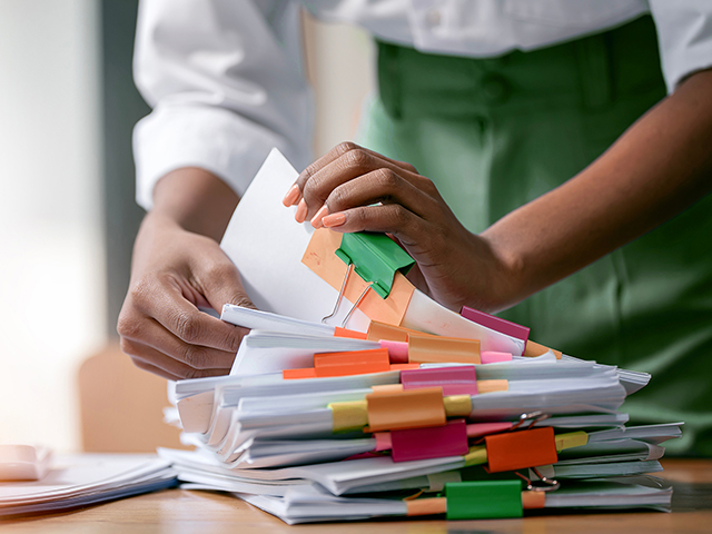 closeup of office employee sorting documents at table 