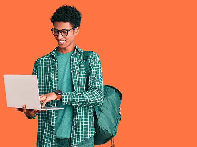 student standing and using a laptop