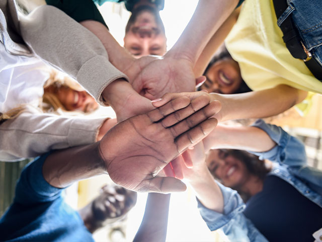 Students putting hands together