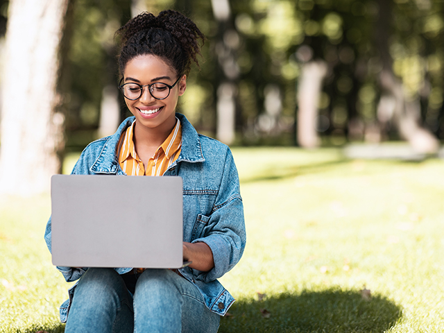 Student outside using laptop