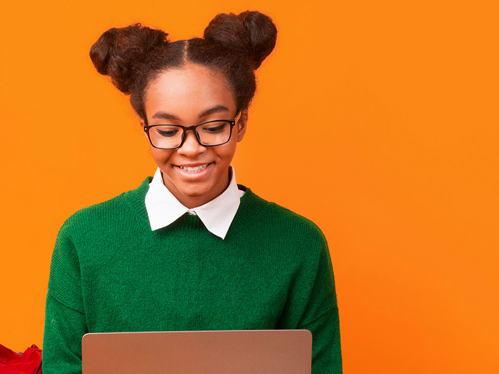 Student wearinf green sweater in front of laptop