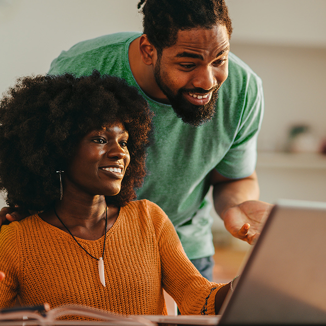 young man and woman using a laptop at a table