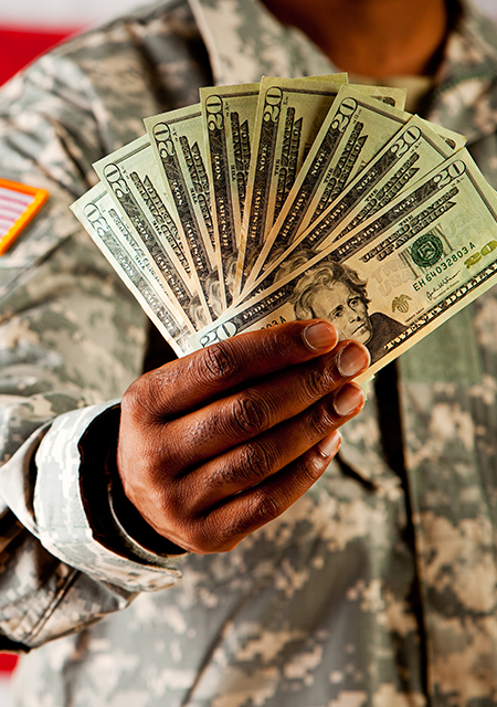 Soldier in uniform holding cash stack