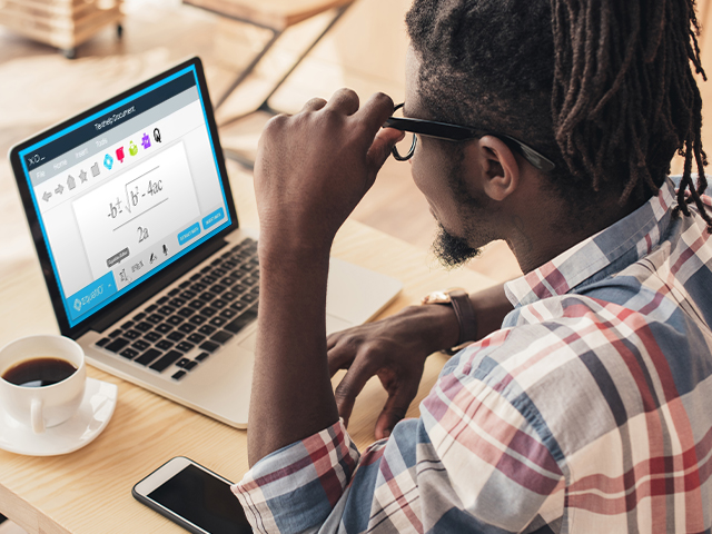 african american young man using laptop in coffee shop