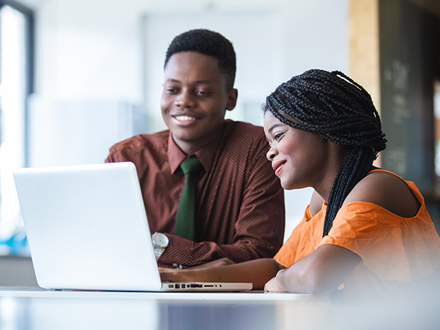 African American Man and young women student using a laptop during a meeting in office