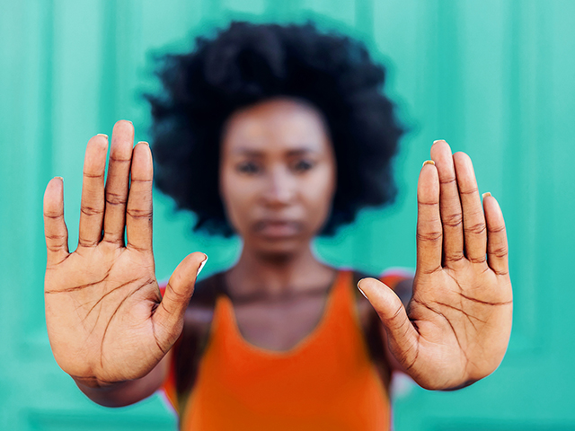 Closeup of african american woman holding hands as a stop sign.